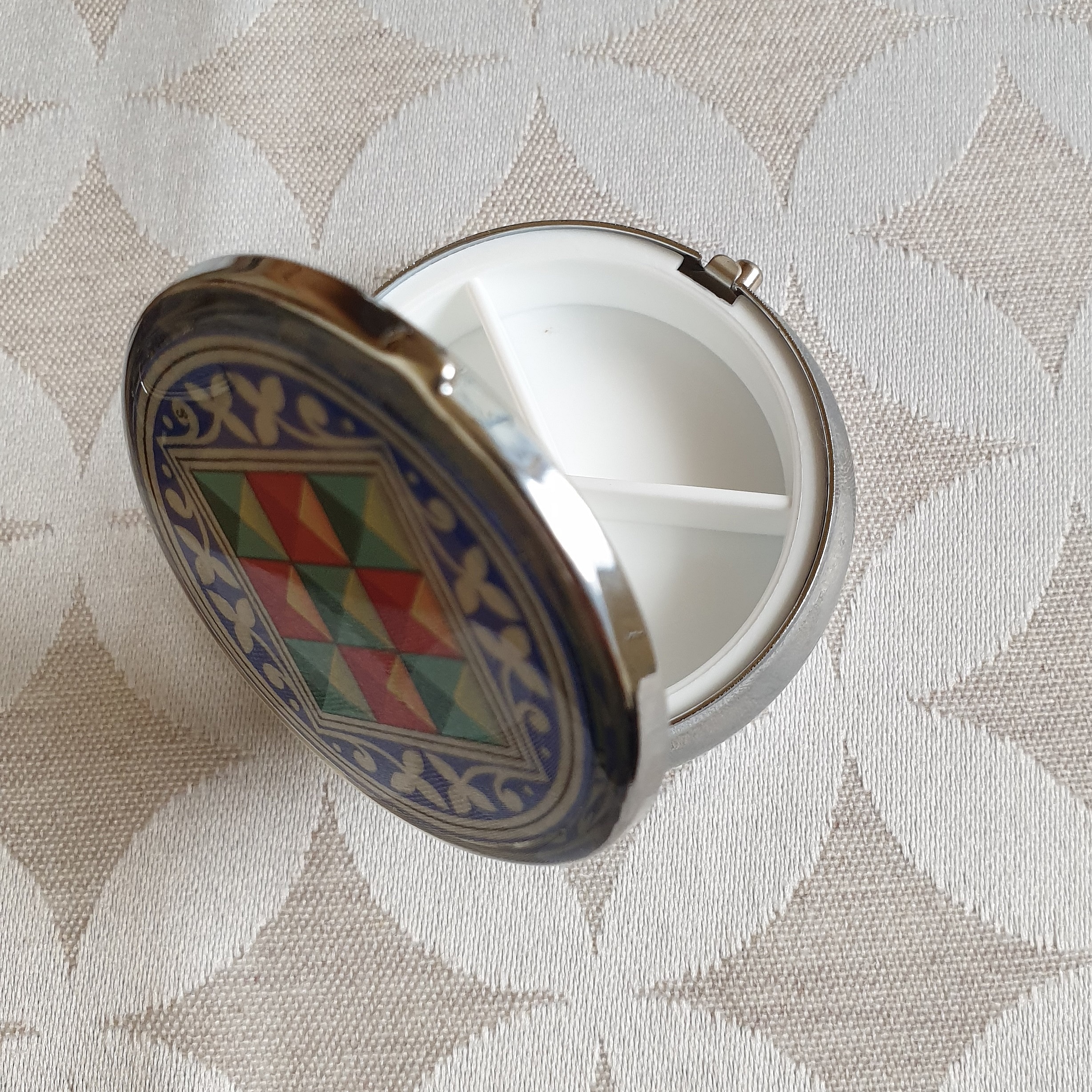 Petit pilulier métallique avec enluminure florentine compartimenté.