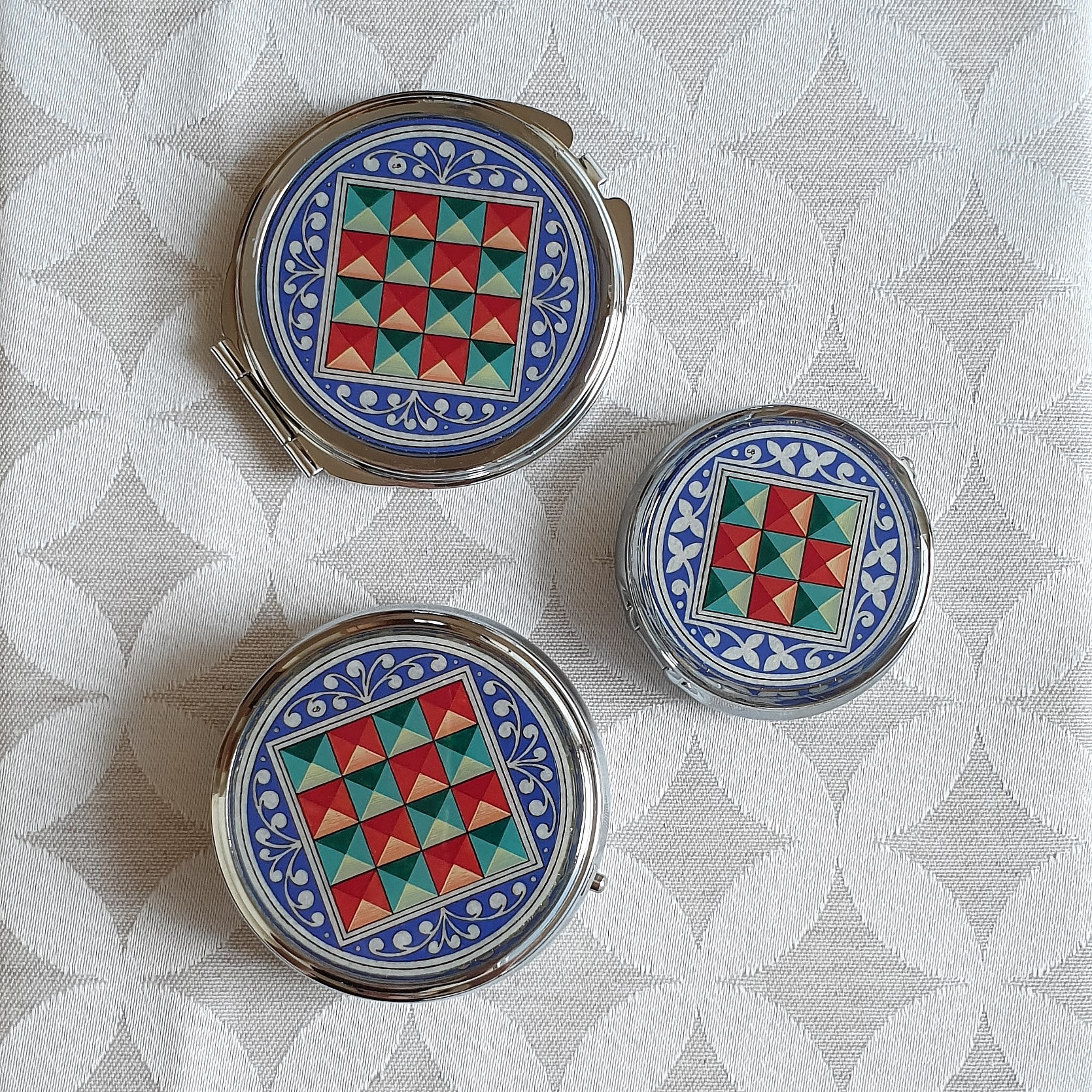 Petits piluliers métalliques ronds avec enluminure florentine artisanale.