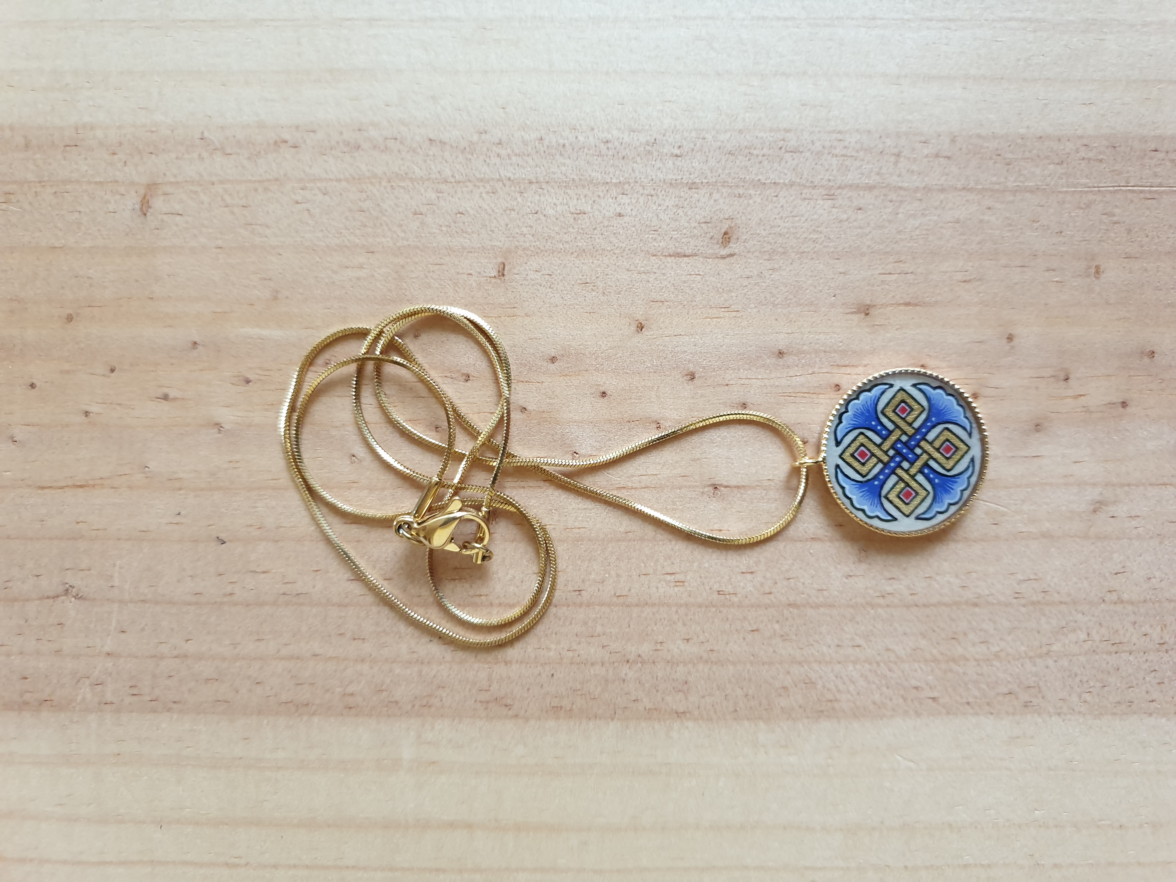 Collana con palmette blu, intrecci dorati e rossi su catena dorata