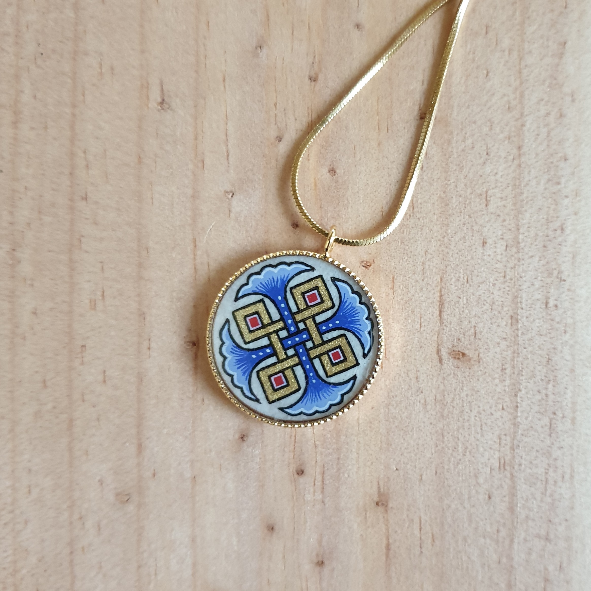 Collana con palmette blu, intrecci dorati e rossi su catena dorata