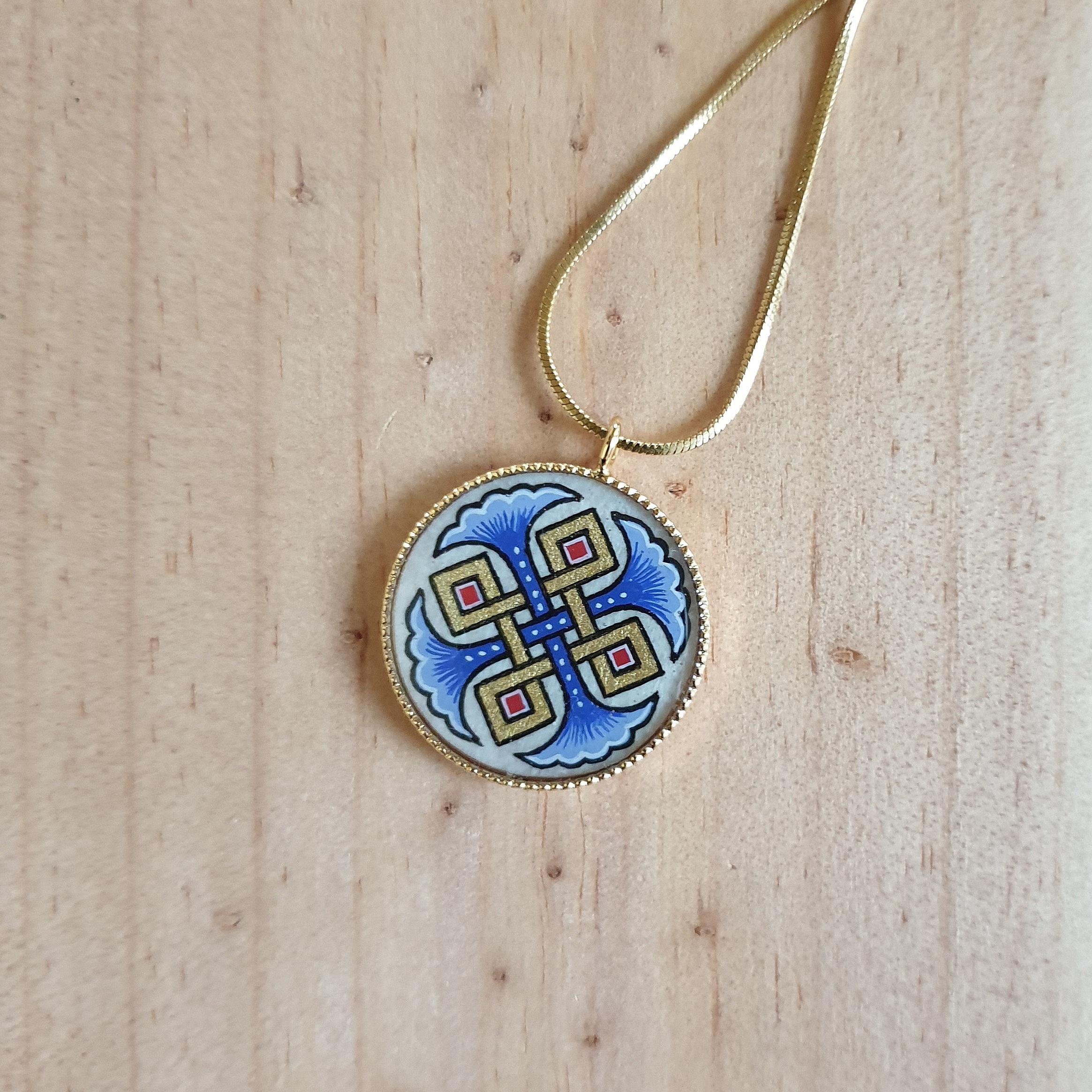Collana con palmette blu, intrecci dorati e rossi su catena dorata